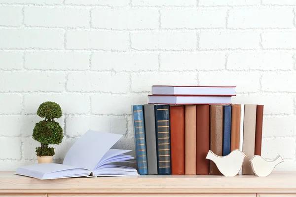 Books on shelf on wall background — Stock Photo, Image
