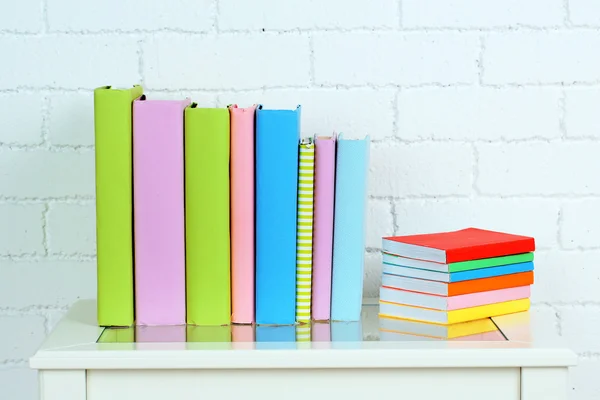 Libros en estante sobre fondo de pared —  Fotos de Stock