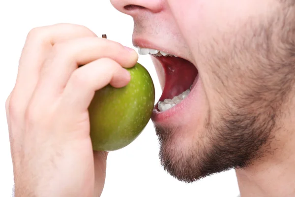 Homem mordendo maçã verde fresca com dentes saudáveis isolados no fundo branco — Fotografia de Stock