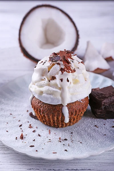 Délicieux cupcake à la noix de coco avec crème et pépites de chocolat sur fond de table en bois couleur — Photo