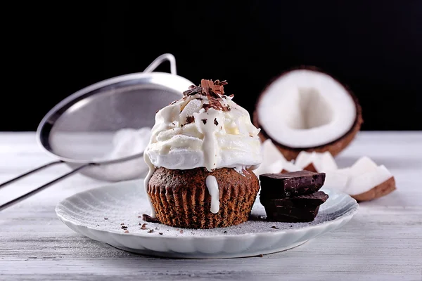 美味的椰子蛋糕奶油和巧克力芯片彩色木桌和黑暗的背景 — 图库照片