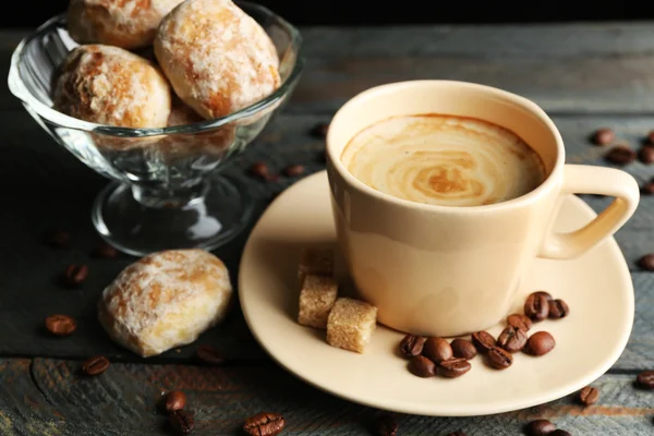 Secangkir kopi dan kue lezat di atas meja kayu, dengan latar belakang gelap — Stok Foto