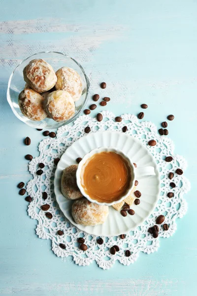 Чашка кави та смачне печиво на кольоровому дерев'яному фоні — стокове фото