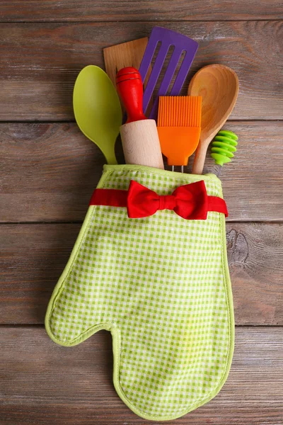 Conjunto de utensílios de cozinha em mitene em pranchas de madeira fundo — Fotografia de Stock