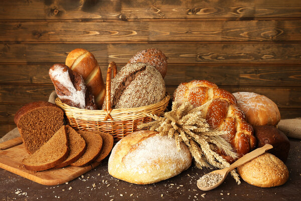 Различные хлеба с ушами в корзине на деревянном фоне
