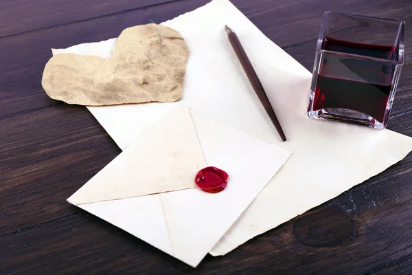 Envelope com caneta e tinta sobre fundo de madeira — Fotografia de Stock