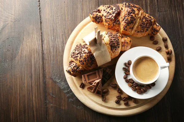 Vers en smakelijk croissants met chocolade en kopje koffie op houten achtergrond — Stockfoto