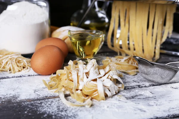 Máquina de hacer pasta de metal e ingredientes para pasta sobre fondo de madera —  Fotos de Stock