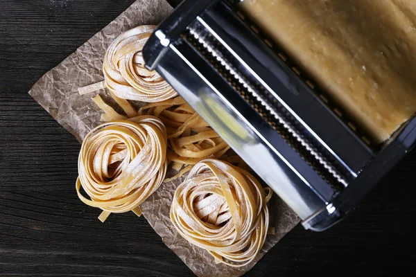 Metal pasta maker machine and ingredients for pasta on wooden background — Stock Photo, Image