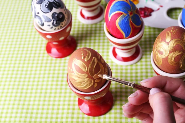 Jovem mulher pintando ovos de Páscoa na mesa de perto — Fotografia de Stock