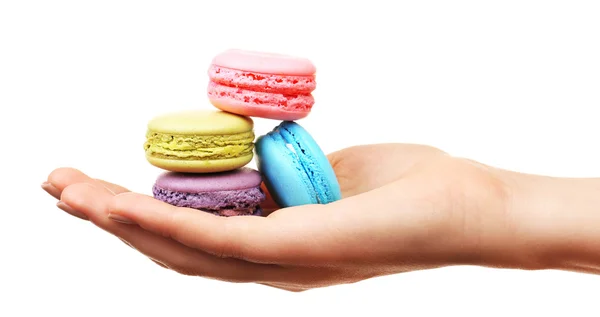 Läckra färgglada macaroons i kvinnlig hand isolerad på vit — Stockfoto