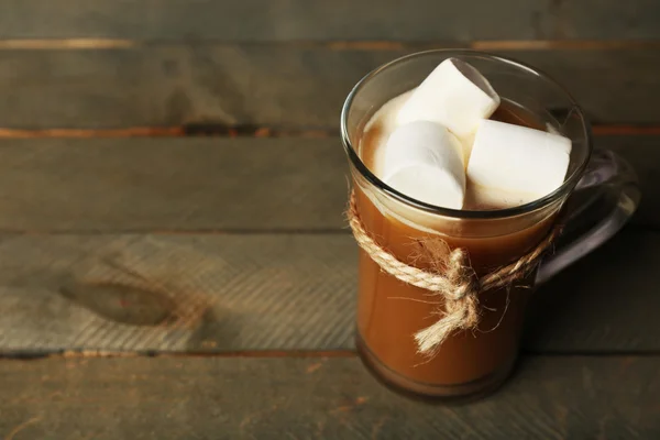 Cangkir kaca coklat dengan marshmallow pada latar belakang papan kayu pedesaan — Stok Foto