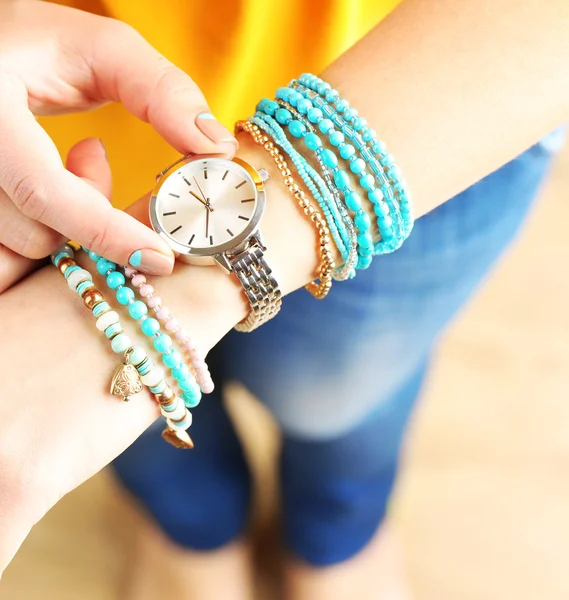 Pulseras con estilo y reloj en la mano femenina de cerca — Foto de Stock