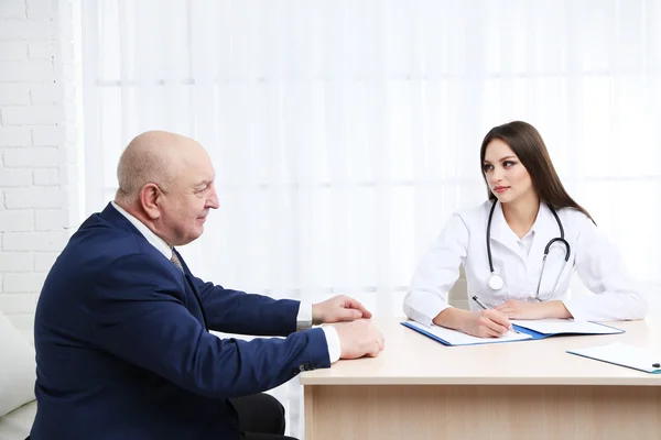 Young female doctor receiving patient in her office — Stock Photo, Image