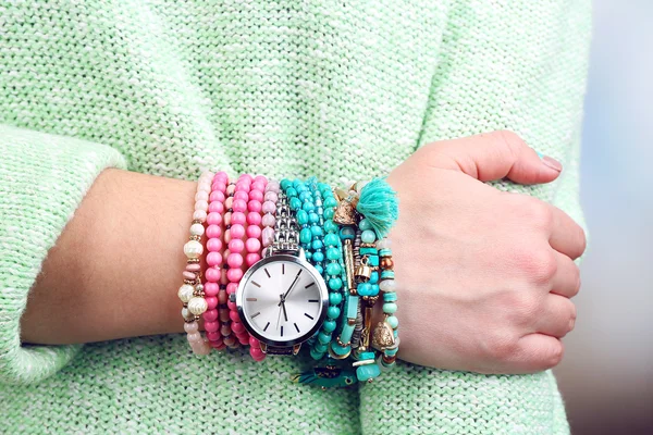 Stylish bracelets and clock on female hand close-up — Stock Photo, Image