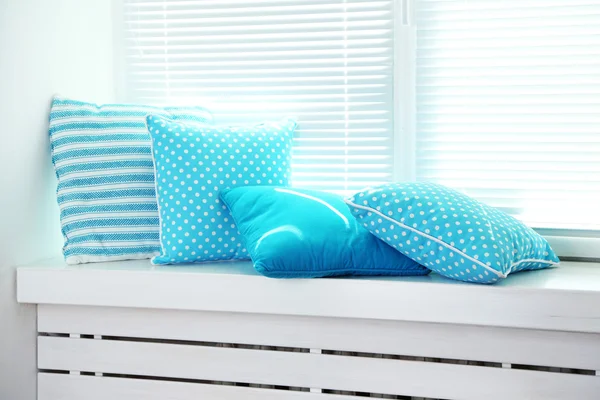 Colorful pillows on windowsill — Stock Photo, Image