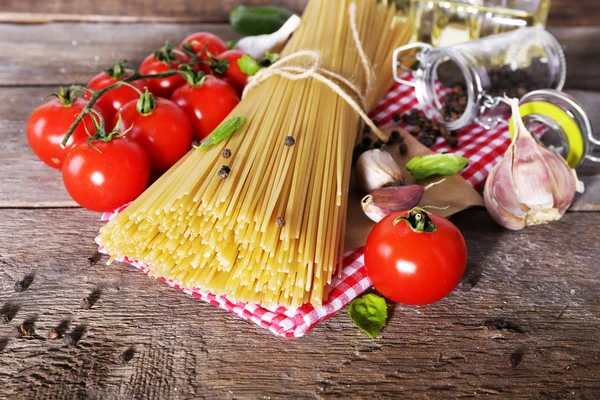 Makaron z pomidorkami i innych składników na drewnianym stole tło — Zdjęcie stockowe