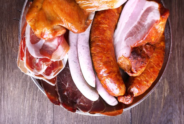 Assortment of deli meats on metal tray on color wooden background — Stock Photo, Image