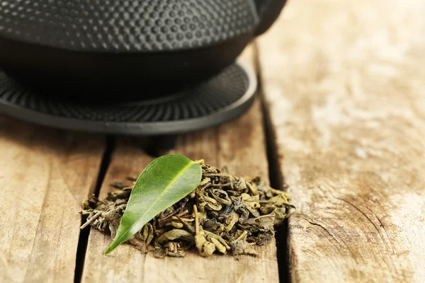 Té verde con hoja sobre mesa de madera vieja —  Fotos de Stock