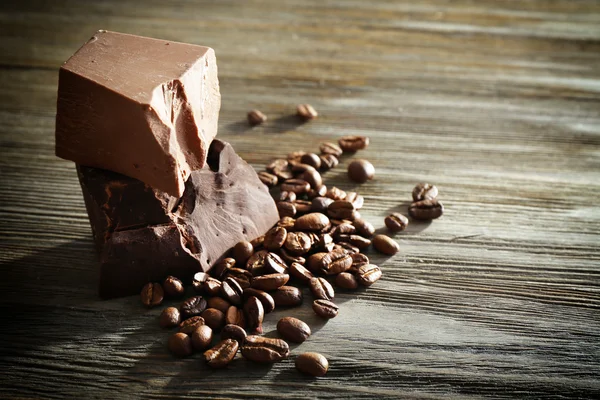 Barras de chocolate com grãos de café em fundo de madeira — Fotografia de Stock