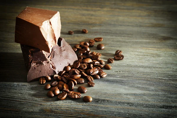 Chocoladerepen met koffiebonen op houten achtergrond — Stockfoto