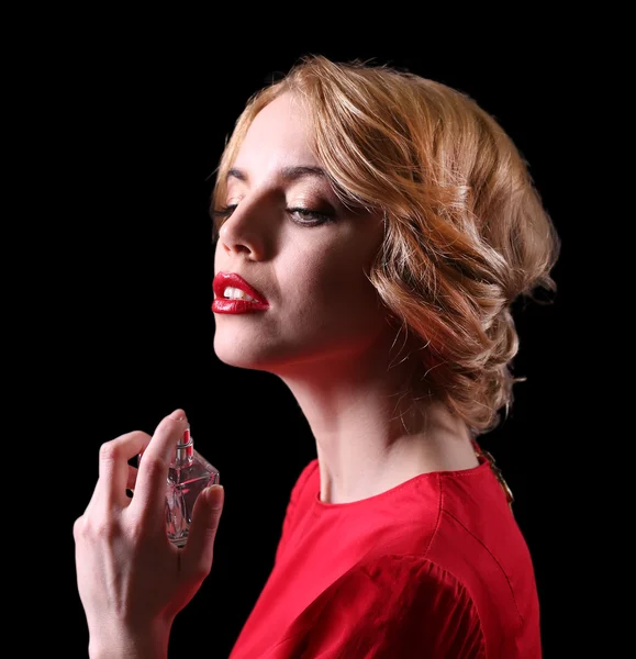 Beautiful young woman with perfume bottle on black background — Stock Photo, Image