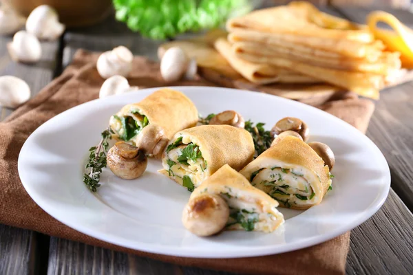 Frittelle con funghi cremosi in piatto su tavolo di legno, primo piano — Foto Stock