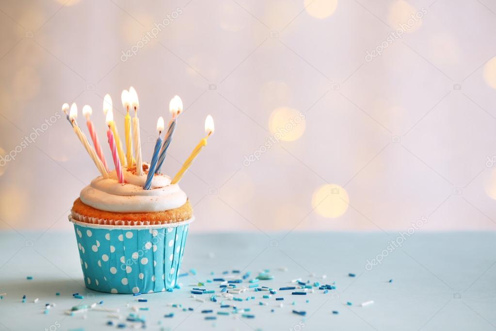 Delicious birthday cupcake on table on light background Stock Photo by