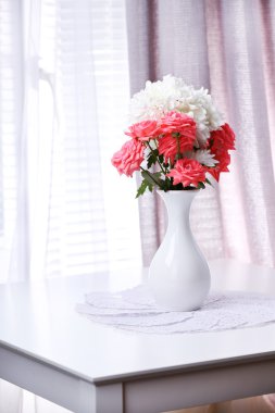 Vazodaki güzel çiçekler Pencereden gelen ışıkla
