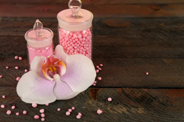 Composition with orchid and bottle of sea salt on wooden background — Stock Photo, Image