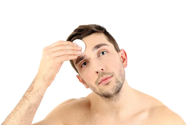 Handsome young man cleansing face isolated on white — Stock Photo, Image