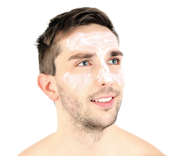 Hombre joven guapo con loción de crema en la cara aislado en blanco — Foto de Stock