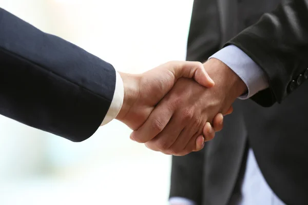 Business handshake on bright background — Stock Photo, Image