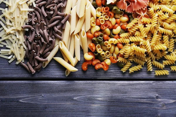 Diferentes tipos de pasta sobre tablones de madera fondo —  Fotos de Stock