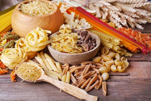 Different types of pasta on wooden table background — Stock Photo, Image