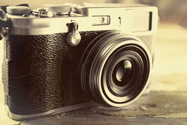 Retro kamera på gamla träbord bakgrund — Stockfoto