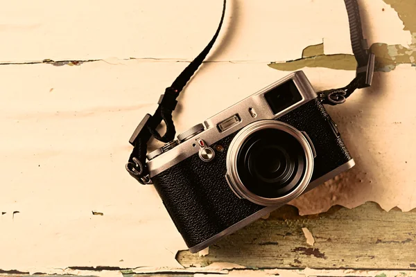 Retro camera on old color wooden table background — Stock Photo, Image