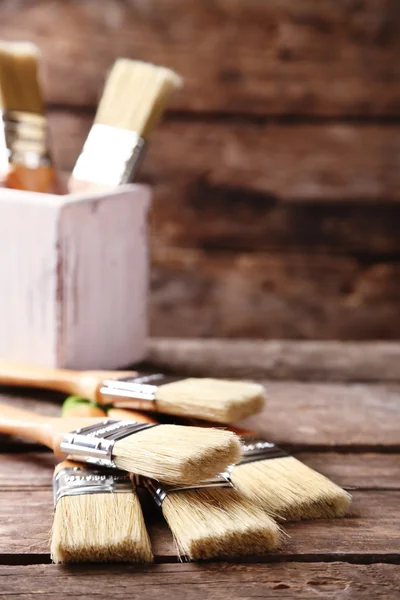 Paint brushes on old wooden background — Stock Photo, Image