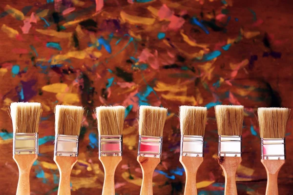 Paint brushes on old wooden background — Stock Photo, Image