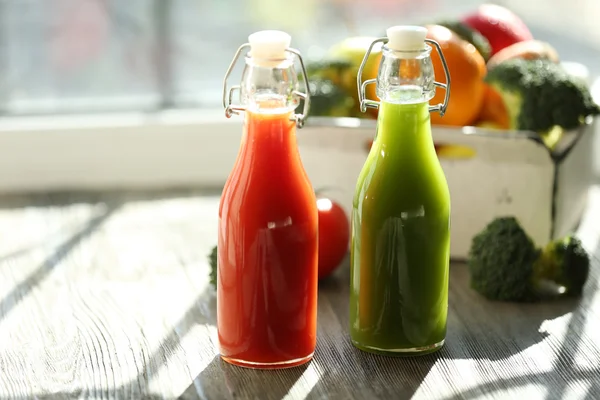 Botellas de jugo con frutas y verduras en cajón en alféizar de ventana — Foto de Stock