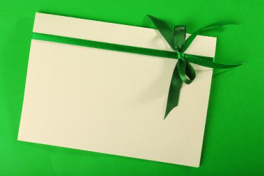 Yeşil arka plan üzerinde yay ile dekore edilmiş kartı