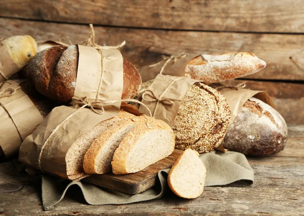 Pane fresco diverso, su vecchio tavolo di legno — Foto Stock