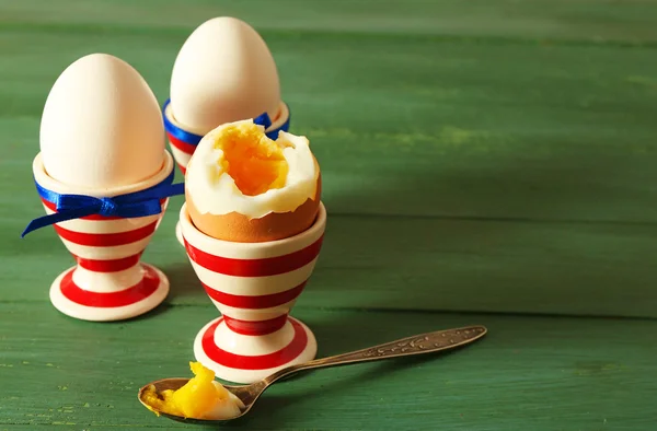 Варені яйця в тримачах на кольоровому дерев'яному фоні — стокове фото