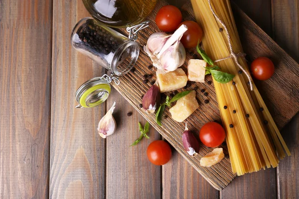 Pastas crudas con queso y verduras sobre fondo de madera —  Fotos de Stock