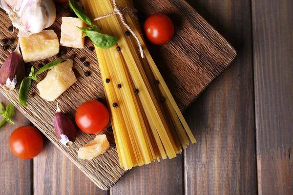 Pâtes crues au fromage et légumes sur fond de bois — Photo