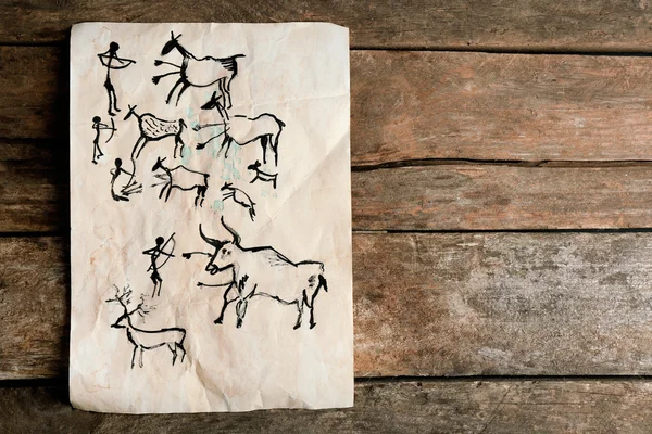 Kalliomaalauksia paperilla puupohjalla — kuvapankkivalokuva