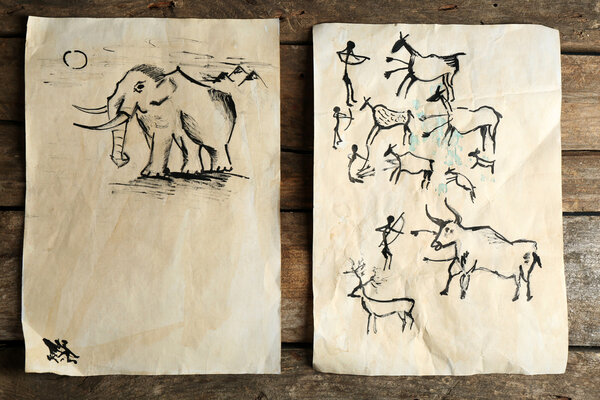 Rock paintings on paper on wooden background