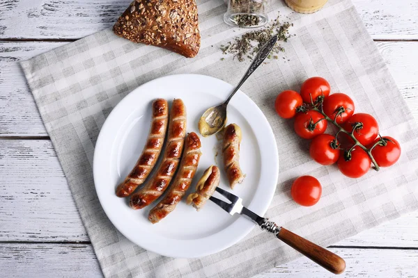 Ekmek ile plaka üzerinde ızgara sosis ve domates tablo üzerinde kapat