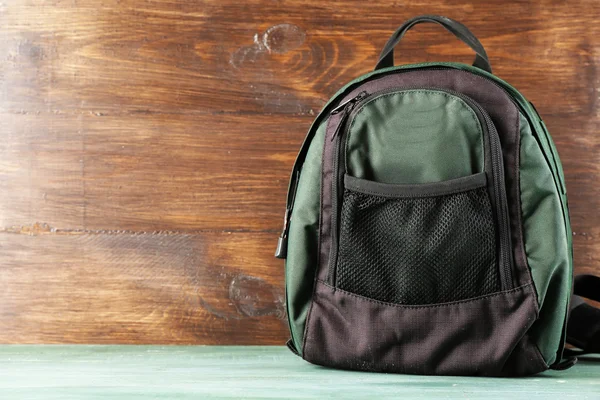 Backpack on wooden background — Stock Photo, Image