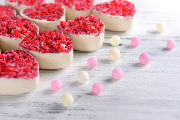 Deliciosos doces de chocolate em forma de coração na mesa close-up — Fotografia de Stock